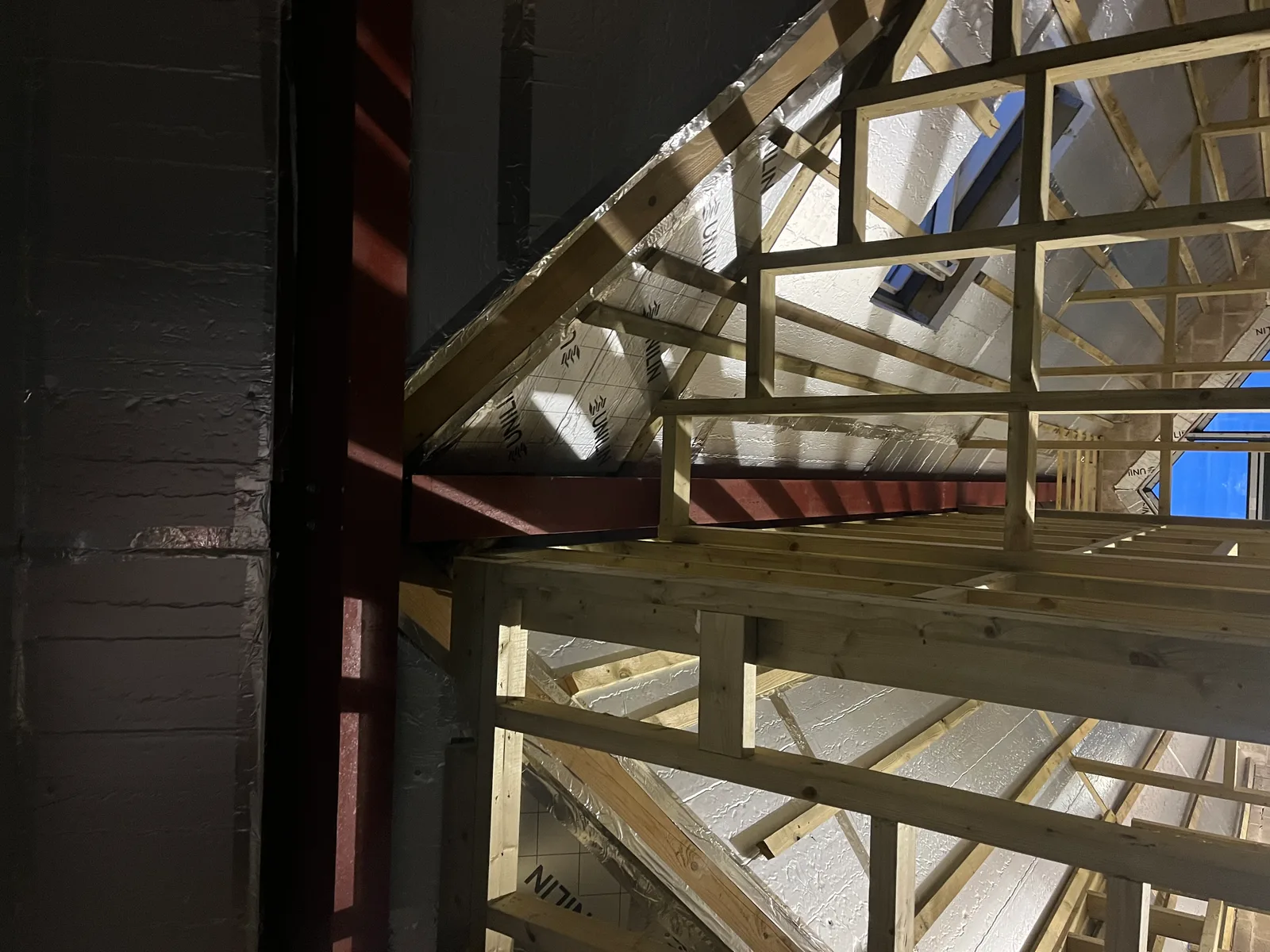 Foil-faced PIR insulation fitted between rafters of a pitched roof build with Velux skylights